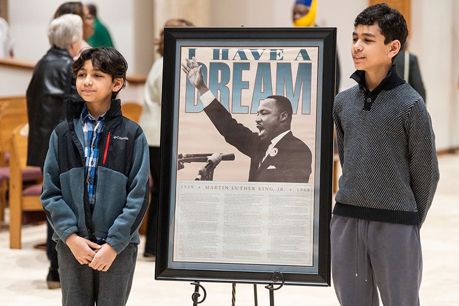 Two boys stand before an MLK sign in a church
